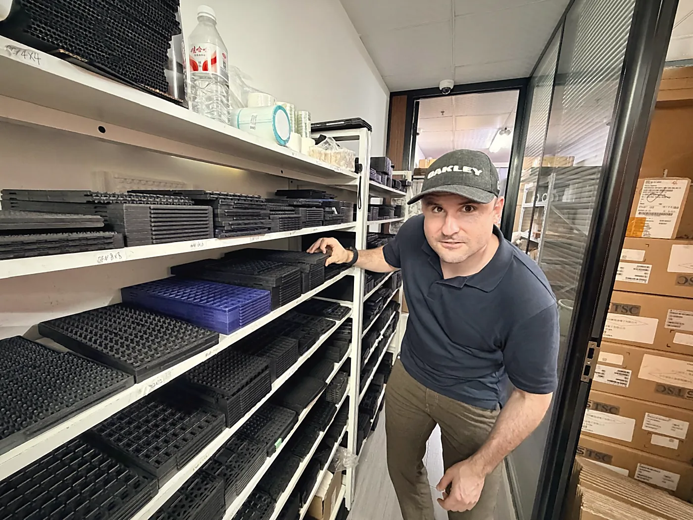 Sebastian Kirsch am Regal mit Bauteil-Trays im Lager eines chinesischen Lieferanten
