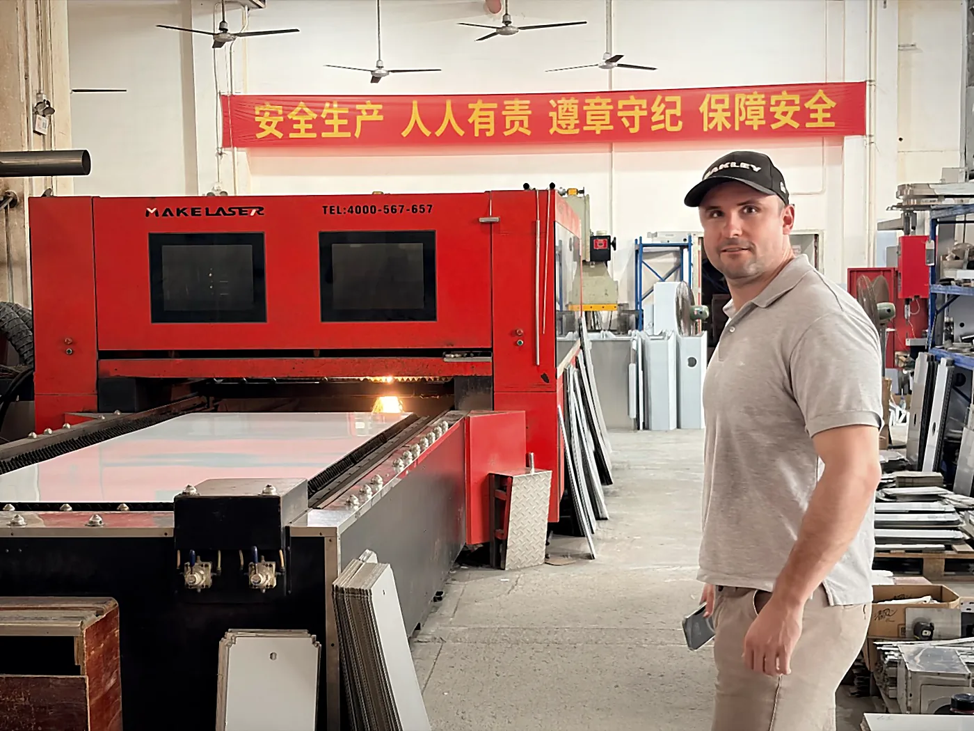 Sebastian Kirsch in a Chinese production hall in front of a laser cutting machine