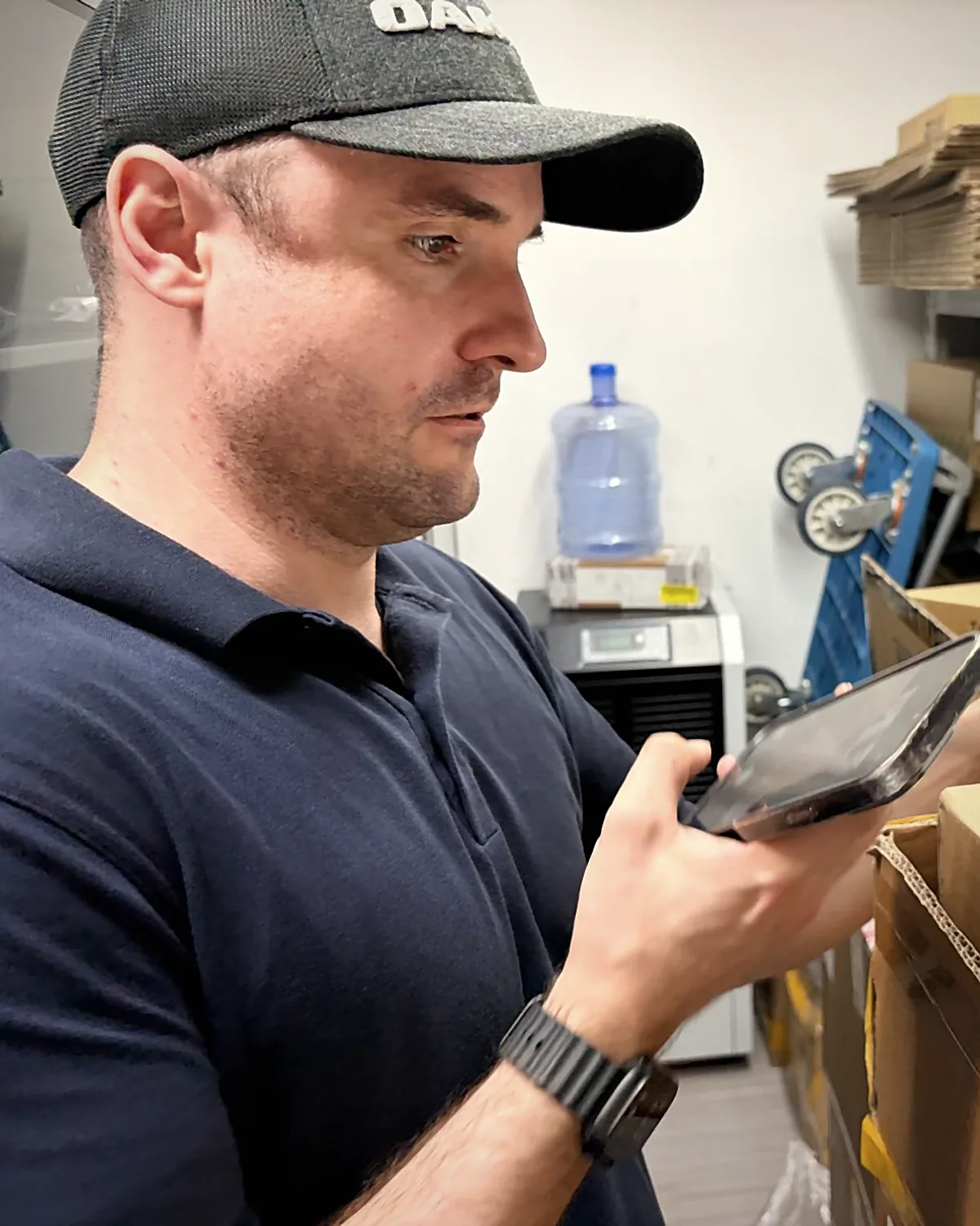 Sebastian Kirsch checking a packaged circuit board against the data on his tablet in the warehouse of a Chinese supplier