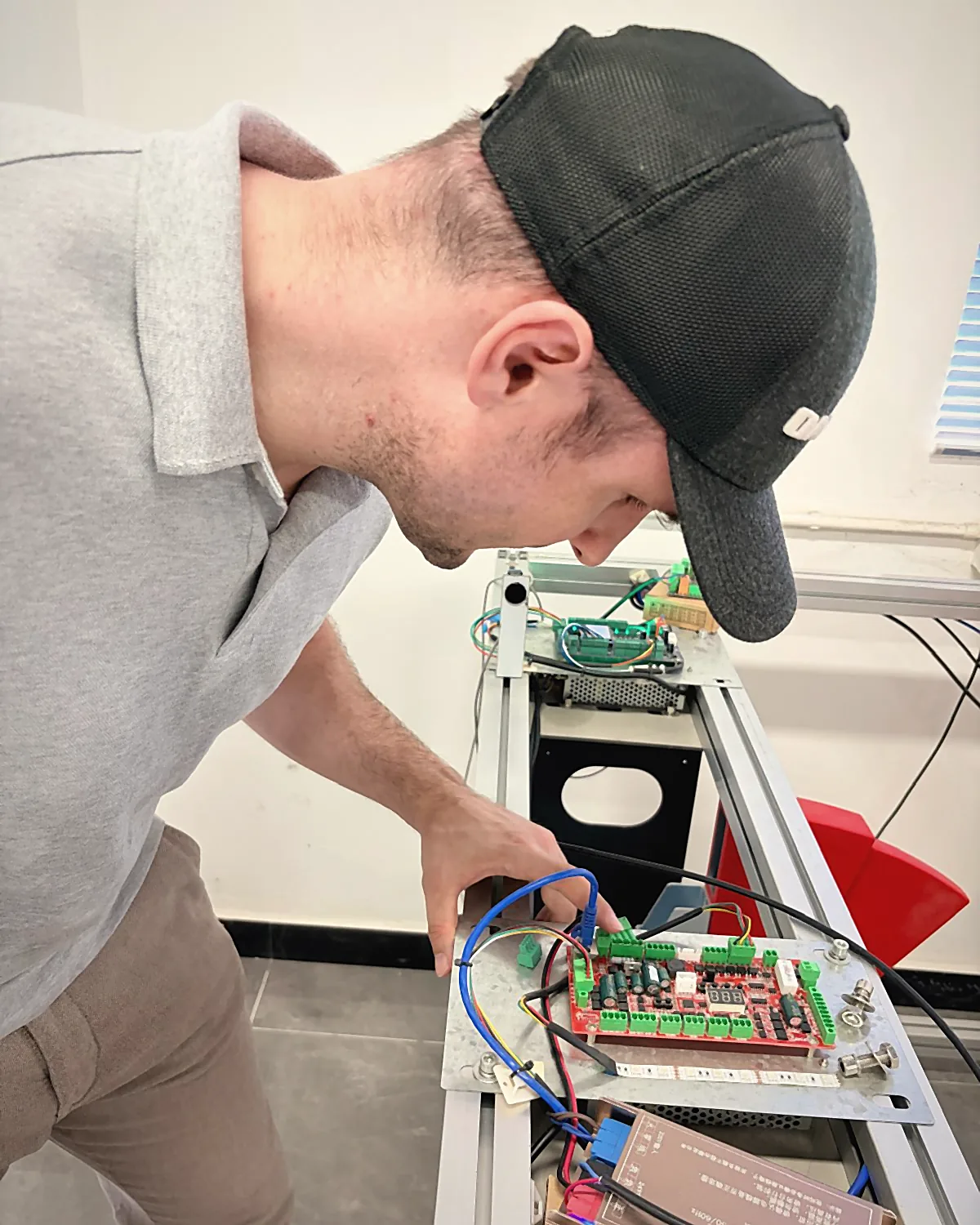 Sebastian Kirsch leaning over a test setup with a control board