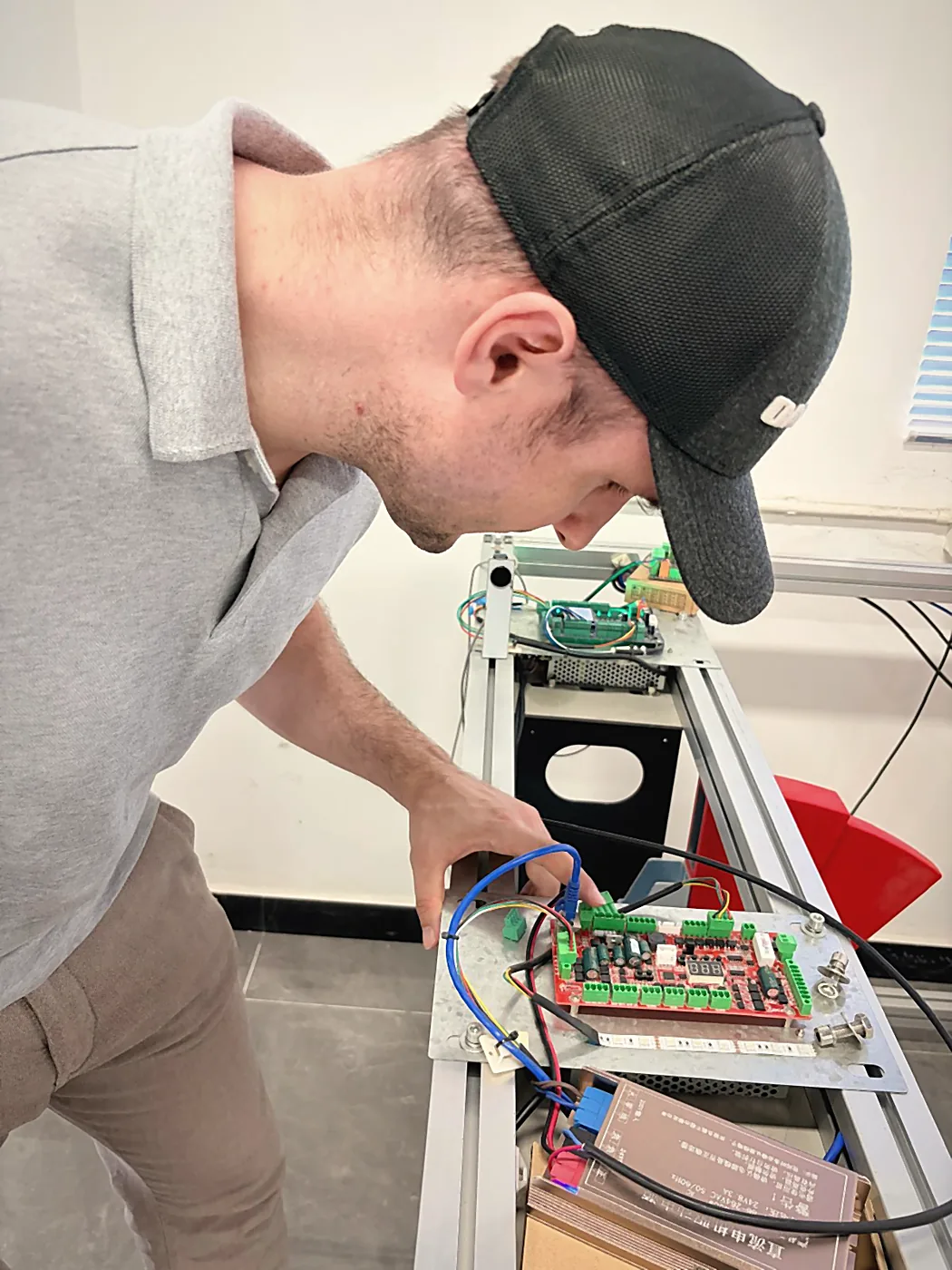 Sebastian Kirsch inspecting a test setup with control board and cabling in Shenzhen